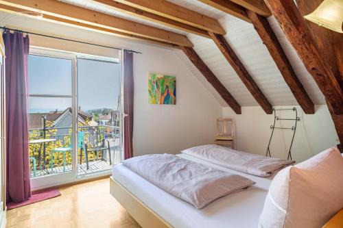 two beds in a room with a large window at Obst- Ferienhof Ragg in Immenstaad am Bodensee