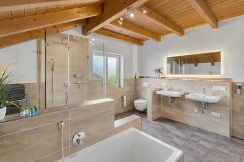 a bathroom with two sinks and a shower at Cosy Home Allgäu in Haldenwang