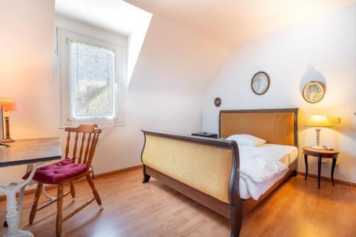 a bedroom with a bed and a desk and a chair at Escapade Sérénité - Les Alignements in Carnac
