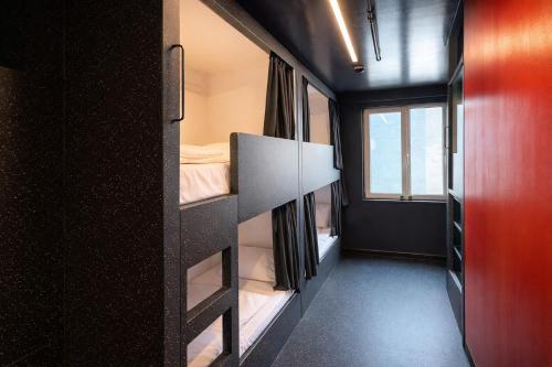 a room with two bunk beds and a window at AMISTAT Hub Hostel Budapest in Budapest