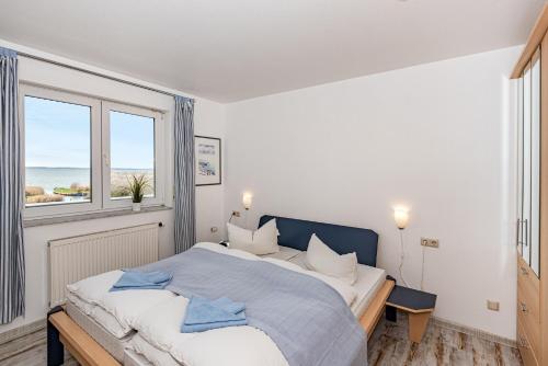 a bedroom with a large bed and a window at Aquarius Ferienwohnung Usedom in Loddin