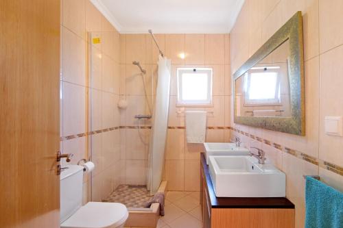 a bathroom with a sink and a shower and a toilet at Casa Palma in Paderne