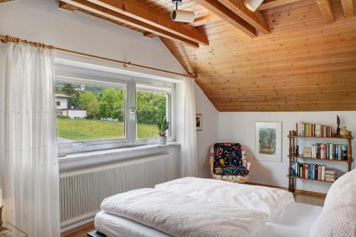 a bedroom with a bed and a window and a book shelf at Haus Gutschi in Imst