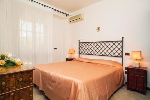 a bedroom with a bed and a dresser with two lamps at Garden Cottage I Dammusi - Arancio in Castelmola
