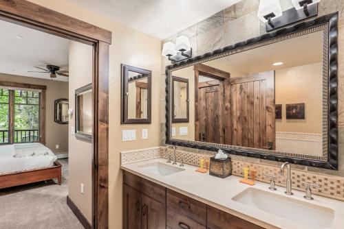 a bathroom with two sinks and a large mirror at Luxe Breck Escape - 2BR & 2BA with Pool, Hot Tubs & Walk to Downtown in Breckenridge