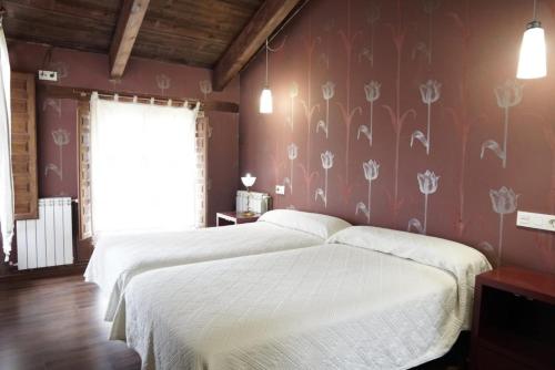 a bedroom with two beds and a floral wall at La Platería I in Mambrilla de Castrejón