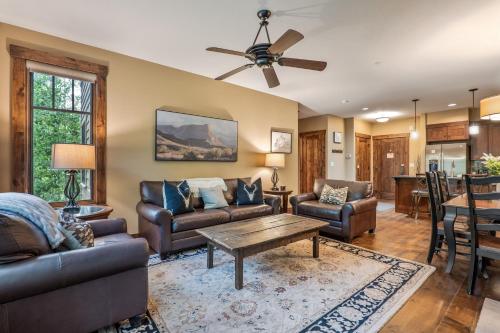 a living room with leather furniture and a ceiling fan at Luxe Breck Escape - 2BR & 2BA with Pool, Hot Tubs & Walk to Downtown in Breckenridge