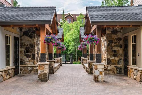 a stone house with flower baskets on the entrances at Luxe Breck Escape - 2BR & 2BA with Pool, Hot Tubs & Walk to Downtown in Breckenridge