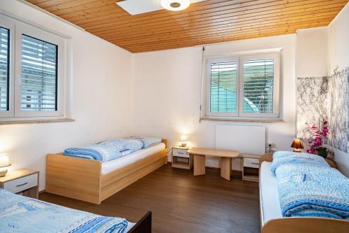 two beds in a room with two windows at Nguyen und Le 2 in Neukirch