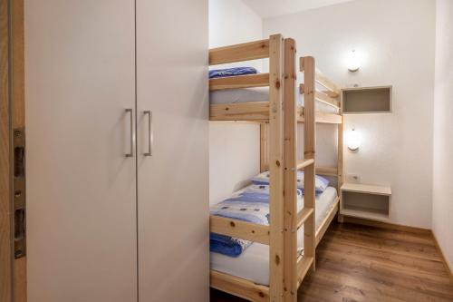 a bunk room with two bunk beds and a closet at App Sonne Nr 16 in Lutago