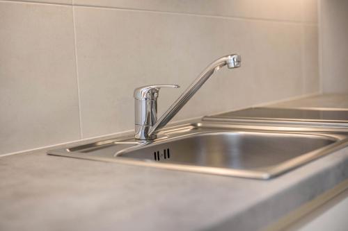 a stainless steel kitchen sink with a faucet at App Sonne Nr 16 in Lutago