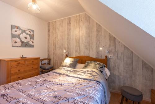 a bedroom with a bed and a wooden wall at Gite Clarabide in Loudenvielle