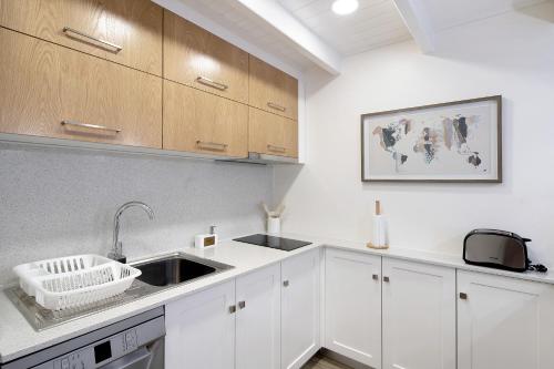 a kitchen with white cabinets and a sink at Adega do Portinho Velho in Piedade
