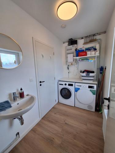 a bathroom with a washing machine and a sink at Ma maison de famille in Saint-Hubert