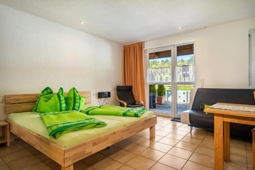 a bedroom with a bed with green pillows at Ferienwohnung Buchmann in Deggenhausertal