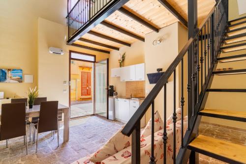 a kitchen and dining room with a staircase in a house at La rimesa di Tittì - Tittì in Alezio