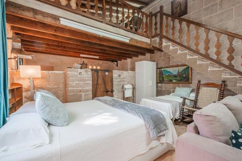 a bedroom with two beds and a couch and a staircase at Segles 11 in Campos