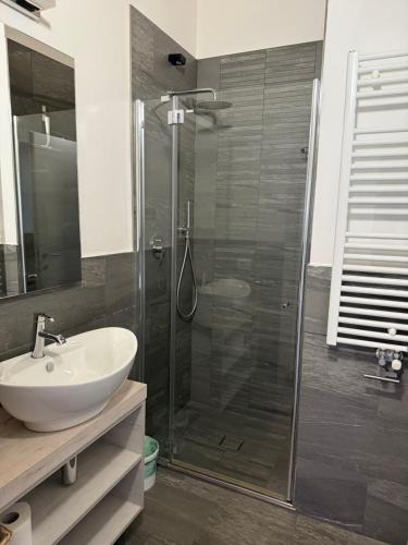 a bathroom with a glass shower and a sink at Sugadoi in Predazzo