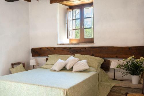 a bedroom with a bed with two pillows and a window at Appartamento Stalla - Cortona in Corgna