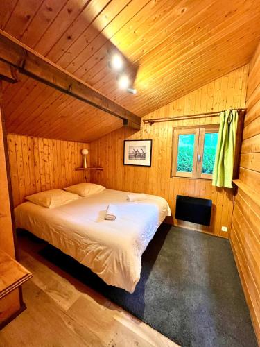 a bedroom with a bed in a wooden cabin at Chalet Mouflon - Vue lac imprenable in Thollon