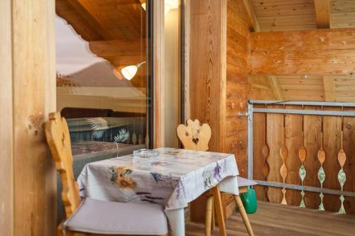 a small table and chair in a room with a balcony at Oberhof Apt Panorama in Vallarga