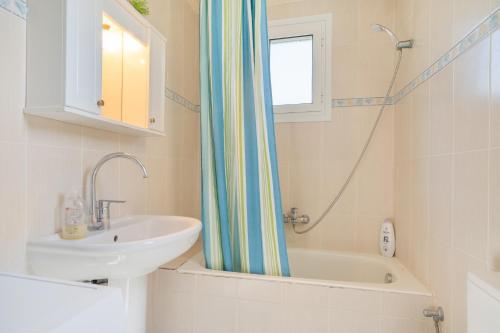 a bathroom with a sink and a shower curtain at Avra in EFL