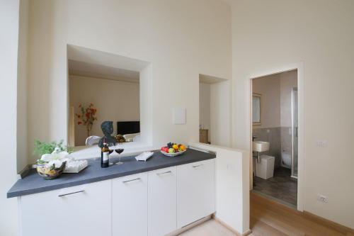uma cozinha branca com um lavatório e um espelho em Proconsolo Superior Suite em Florença