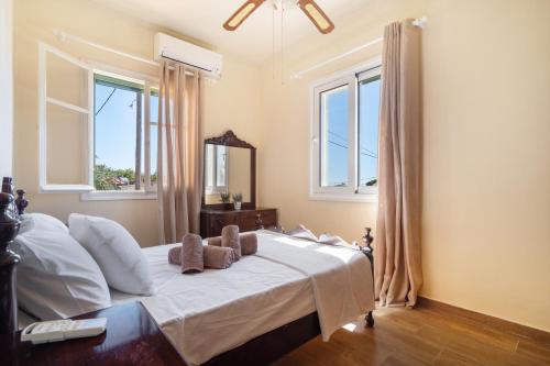 a bedroom with a bed with white sheets and windows at Avra in EFL