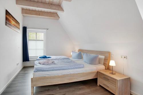 a bedroom with a bed in a room with a window at Ferienhaus Seepferdchen in Dranske