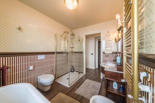a bathroom with a toilet and a shower and a sink at Resort Style Apartment in Perledo