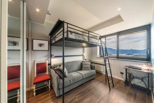 a bedroom with a bunk bed with a couch and a desk at Resort Style Apartment in Perledo