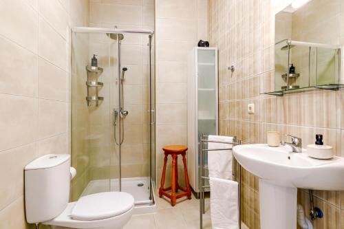 a bathroom with a toilet and a sink and a shower at Ladomar Matriz in Horta