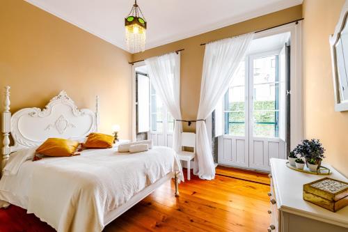 a bedroom with a white bed and a large window at Ladomar Matriz in Horta