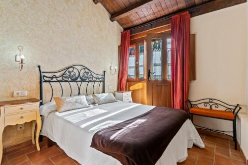 ein Schlafzimmer mit Bett, Schreibtisch und Fenster in der Unterkunft Morouzos in O Porto de Espasante