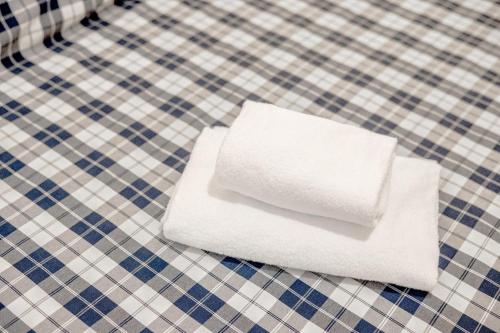 a stack of white towels on a checkered table at La Capannuccia A in Ansedónia