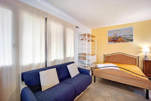 a living room with a blue couch and a bed at Casa Gelsomino in Imperia