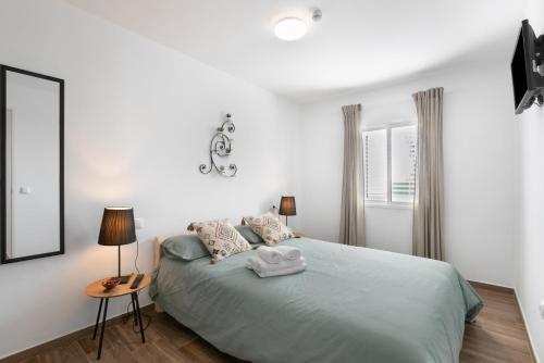 a bedroom with a bed with two lamps and a mirror at Casa Otilia in Arafo