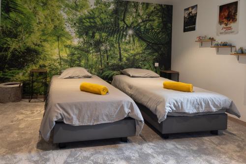 two beds with yellow pillows on them in a bedroom at Chalet La Sentinelle in Bellecombe
