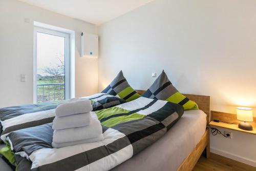 a bedroom with a bed with striped pillows and a window at Zum Krähenholz Wohnung 9 in Husby