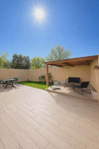 a patio with two picnic tables and benches on it at La Villa Yenna in Vergèze