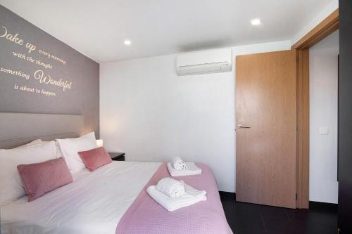 a bedroom with a bed with towels on it at Be Glow Home in Alvor