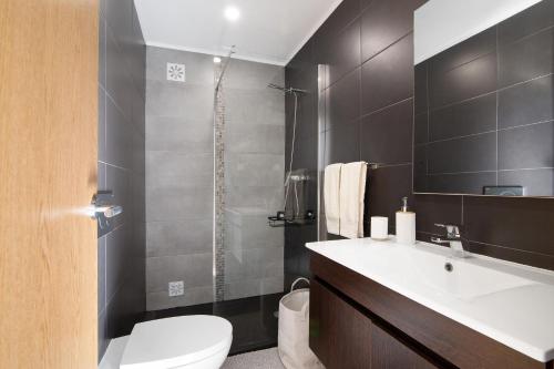 a bathroom with a toilet and a sink and a shower at Be Glow Home in Alvor
