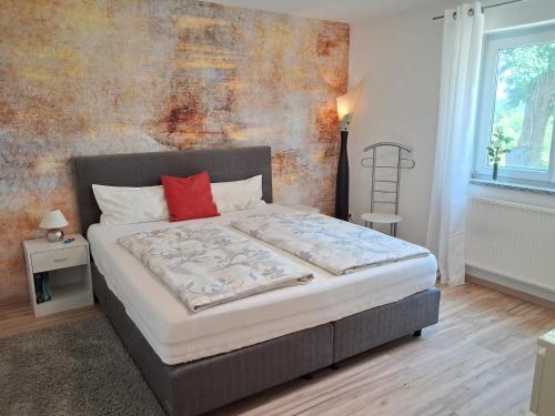 a bedroom with a bed with a red pillow at Tobel Lounge in Sigmarszell