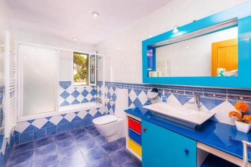 a blue and white bathroom with a toilet and a sink at Villa Malena in Llucmajor
