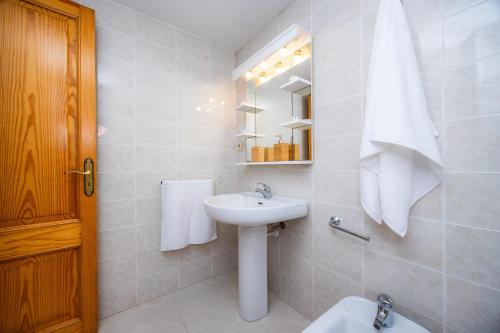 a white bathroom with a sink and a mirror at Marbi in Cala Millor