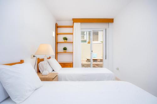 a bedroom with two beds and a window at Marbi in Cala Millor