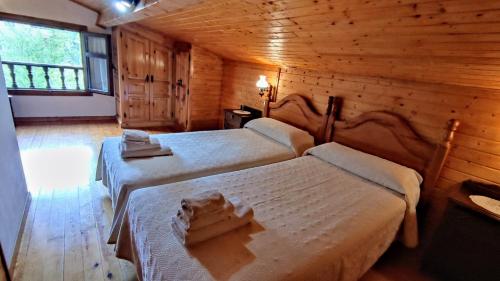 a bedroom with two beds in a log cabin at Apartamento Rural Rubó in Alles