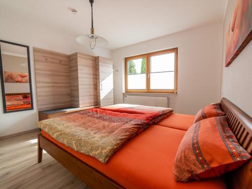 an orange bed in a room with a window at Ferienwohnung Pusteblume in Kappelrodeck