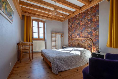 a bedroom with a bed and a wall with a mural at La Chastanha in Saint-Symphorien-de-Mahun