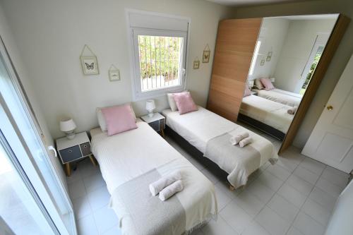 a bedroom with two beds and a mirror at Villa with separate apartment in Mijas Costa